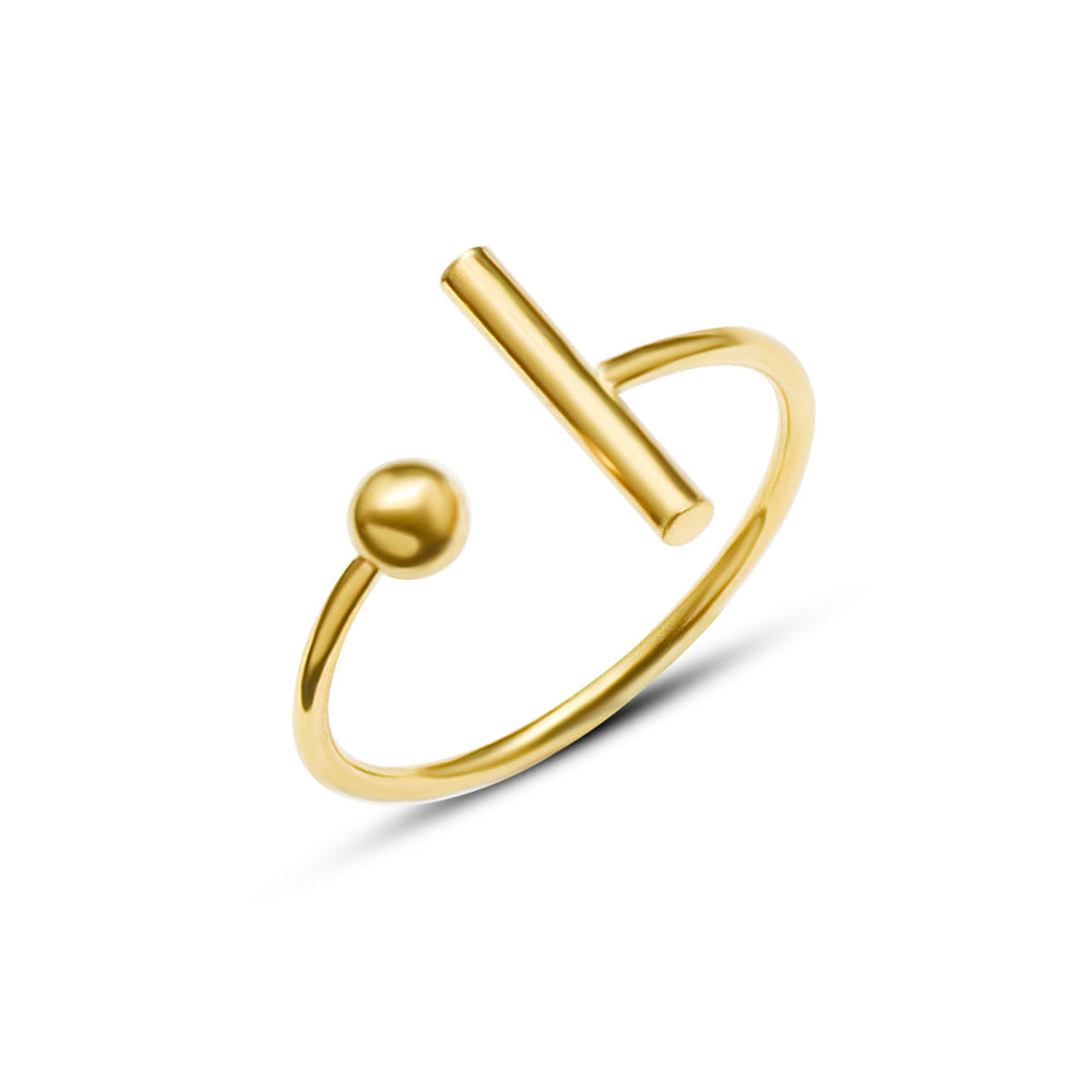 Gold ring with a circular ball and one end and a cylinder at the other